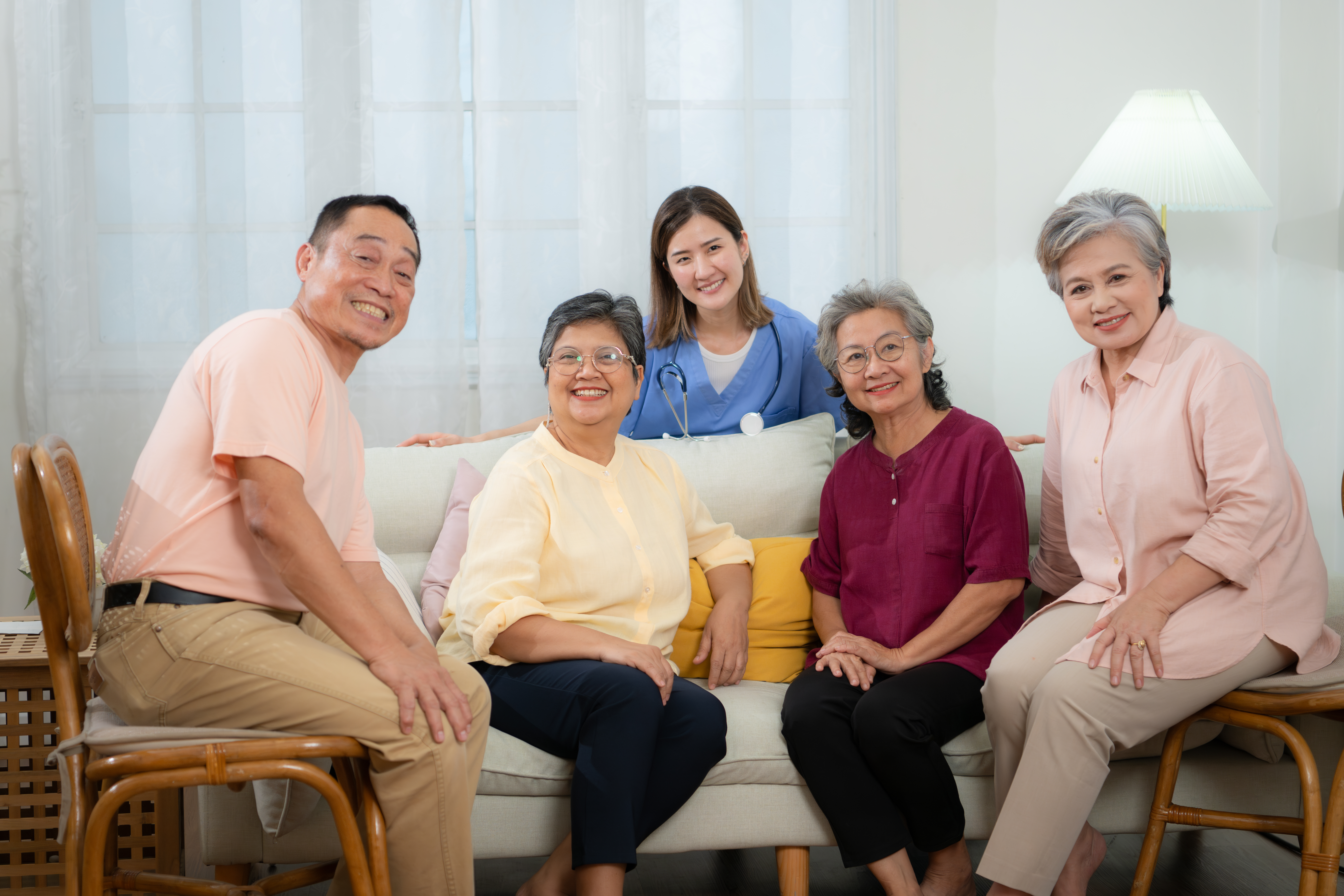 Happy Asian senior family with young female nurse showing family-centered care